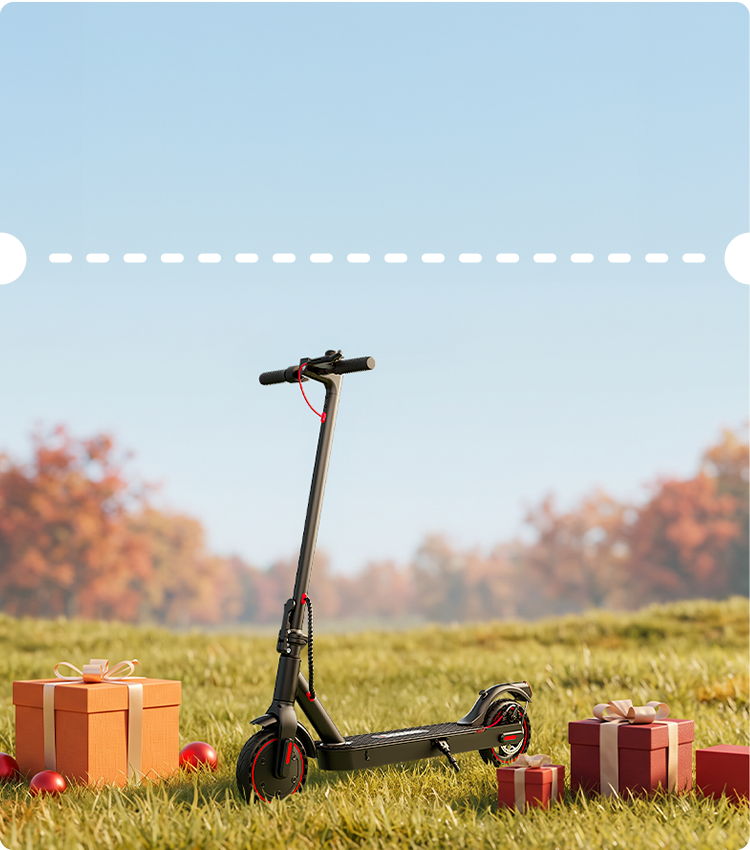 Sunlit outdoor display showing a matte black iScooter i9 electric scooter centered on a grassy field surrounded by festive holiday gifts under a clear blue sky. Crafted for effortless city travel, this lightweight e-scooter features solid honeycomb tires, visible red brake wiring, an integrated kickstand, and a quick-folding handlebar post ideal for convenient portability.