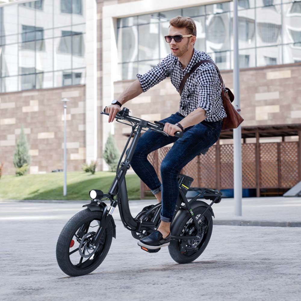 An urban commuting scene features a rider on the iScooter U4 electric bike traveling through a modern city district. The image highlights the low step-through frame, front headlight, removable battery, rear cargo rack, and upright riding position. Combining comfort with practicality, the iScooter U4 is designed to deliver smooth handling and convenient mobility for everyday city rides and short-distance commutes.
