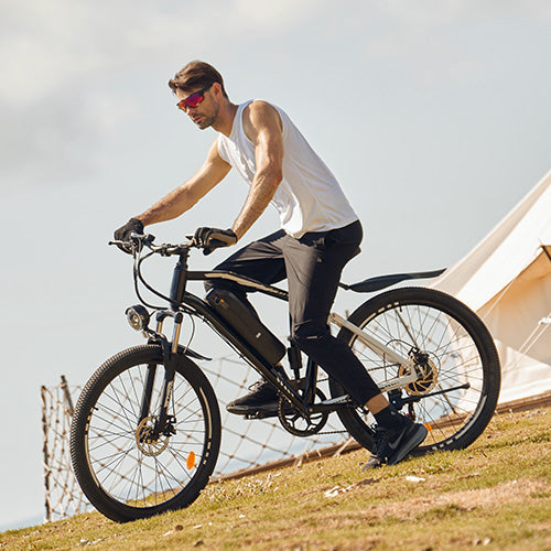Rider on powerful iHoverboard M50 electric mountain bike with integrated battery pack, responsive front suspension, and disc brakes, enjoying gravel path outdoors. The M50 offers long‑range capability, smooth handling on rough terrain, and reliable braking for both recreation and commuting.