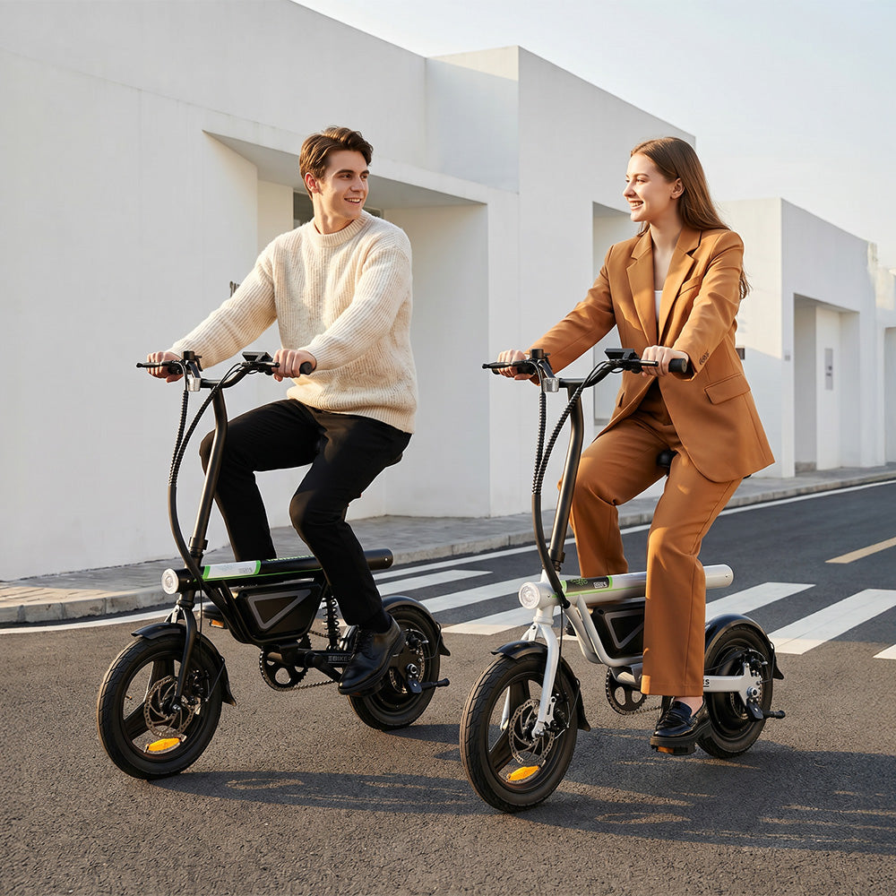 Two adults ride the iScooter EB1S electric bikes side by side on a quiet city street, showcasing both black and white color options. The image highlights the compact folding frame, integrated battery, upright riding position, and agile handling, demonstrating how the iScooter EB1S provides comfortable, practical, and stylish transportation for everyday urban commuting.
