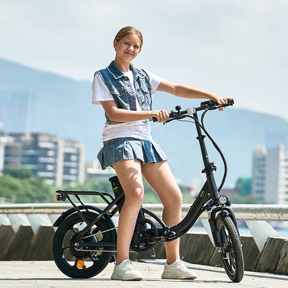A rider stands beside the iScooter U4 electric bike on a waterfront promenade, highlighting its low step-through frame, rear cargo rack, front suspension, and upright handlebar design. Set against a backdrop of mountains and city buildings, the iScooter U4 combines comfort, practicality, and smooth performance, making it ideal for everyday commuting and leisurely outdoor rides.
