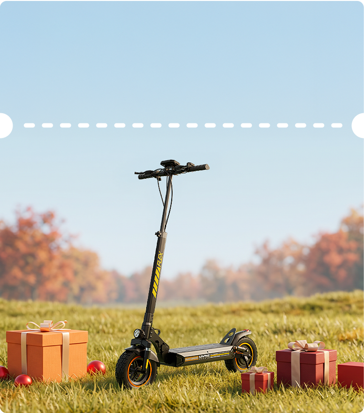 Bright seasonal outdoor showcase featuring a black iScooter W9 Air electric scooter positioned on a sunlit grassy field surrounded by gift boxes with fall trees under a clear blue sky. Designed for versatile riding, this high-performance e-scooter features yellow graphics along the stem, robust treaded tires with orange wheel accents, dual suspension springs, a headlight, and a wide deck for stable, comfortable travels.